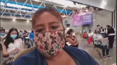 Watch the vaxxed woman in the background as she drops dead